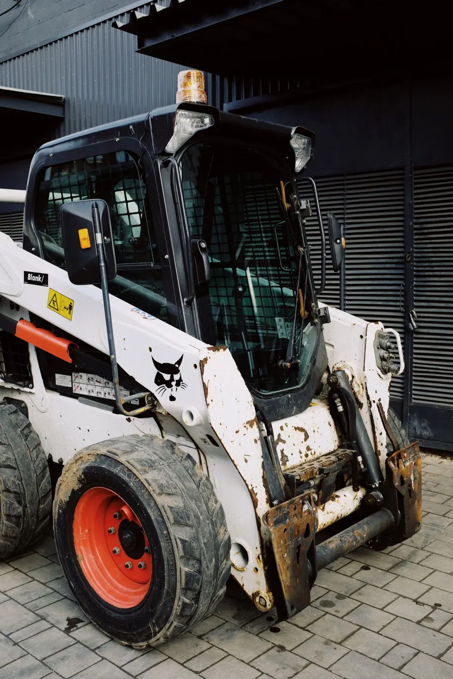 Skid steer & track loader Baton Rouge – Skid steer loader parked in an industrial area (stock photo, Baton Rouge equipment rental guide)
